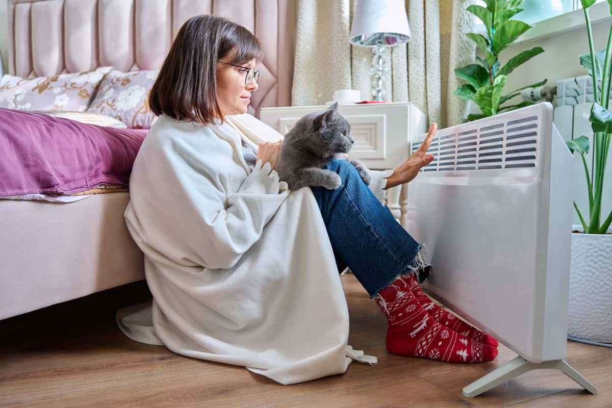 femme avec chat devant radiateur